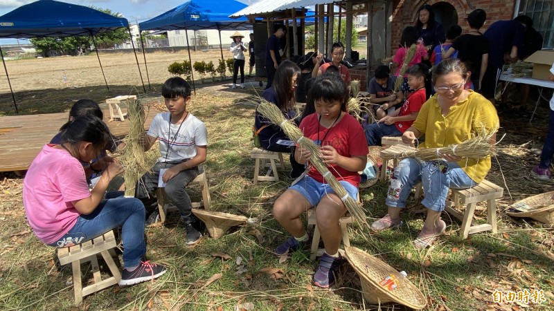 學童學習用稻草綑綁製作球棒。（記者楊金城攝）