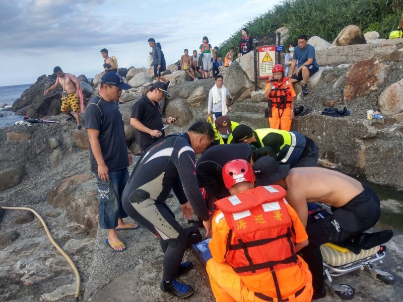 岸巡隊員與救護人員合力將患者抬上擔架，送往醫院搶救（記者吳昇儒翻攝）