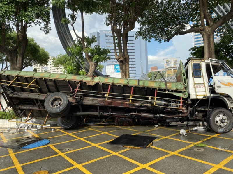 大貨車擦撞加油站內圍牆翻覆。（消防局提供）