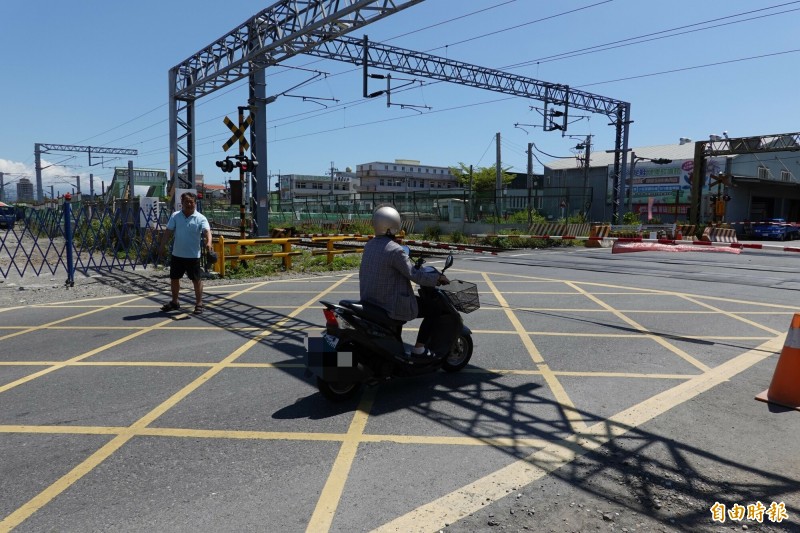 機車騎士在五結鄉中興路平交道等待火車經過時，習慣停在黃網線上，已經違規。（記者江志雄攝）