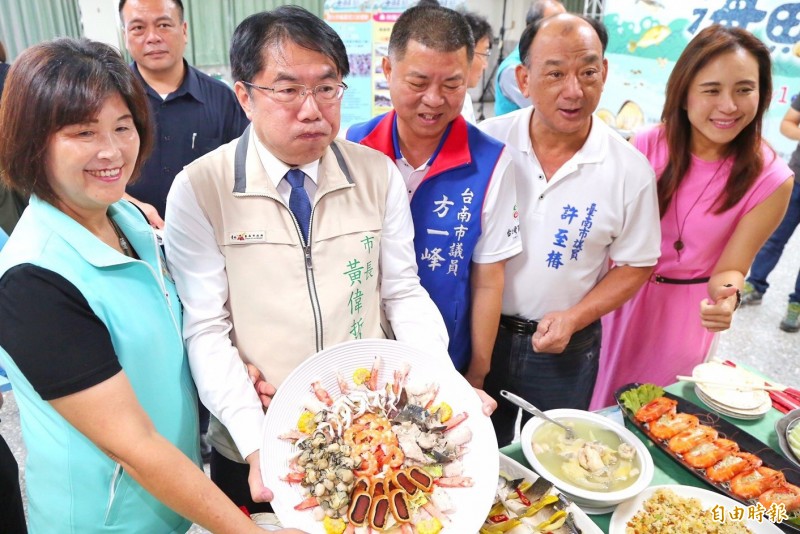 台南市長黃偉哲（前左二）推銷七股七寶宴，因試吃烏魚子炒飯太好吃了，吃到滿嘴鼓鼓。（記者楊金城攝）