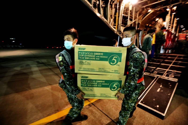 國軍弟兄協助將牛結節疹防疫疫苗搬下飛機。（金門縣政府提供）