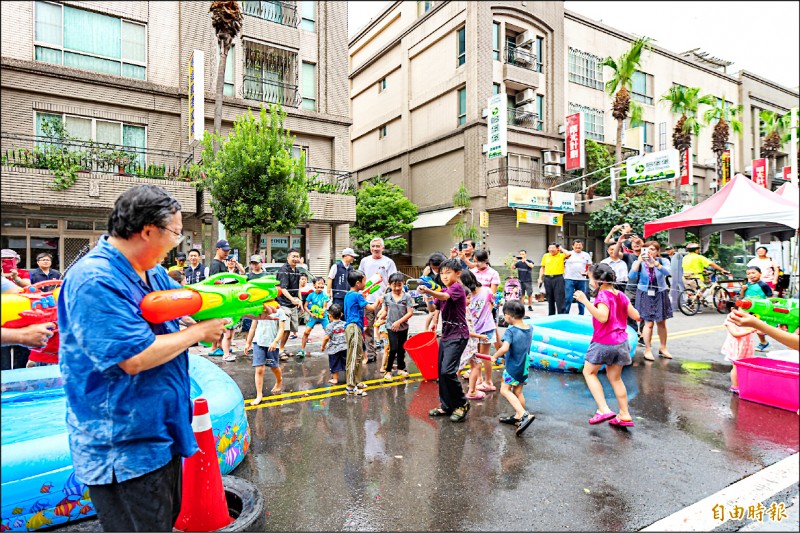 楊梅四維商圈封街辦「水龍節踩街-YOUNG妹是我」活動，鄭文燦（左）到場與小朋友玩水同樂。（記者李容萍攝）