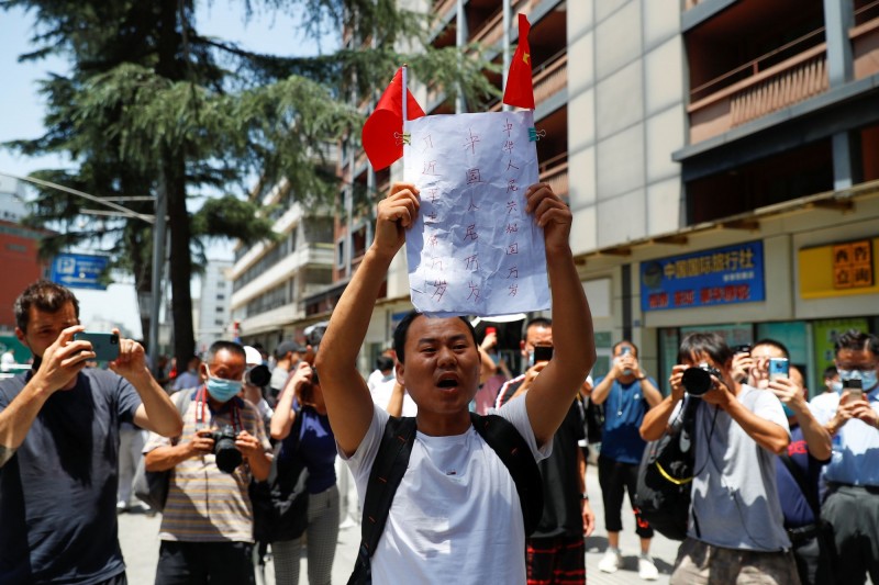 有民眾在現場激動高舉「中國人民萬歲、習近平主席萬歲」，卻慘遭公安帶走。（路透）