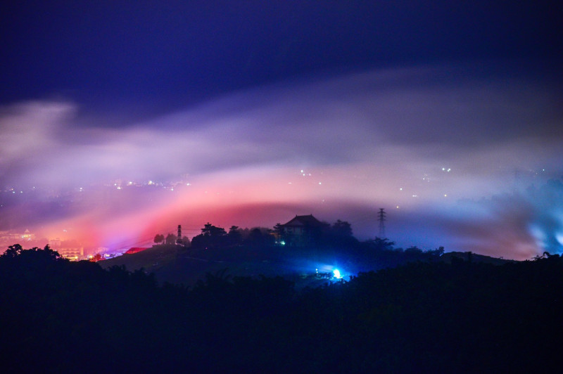 颱風遠颺，但帶來的水氣在日月潭金龍山與市區燈光映照下，呈現有如極光的美景。（陳琪元提供）