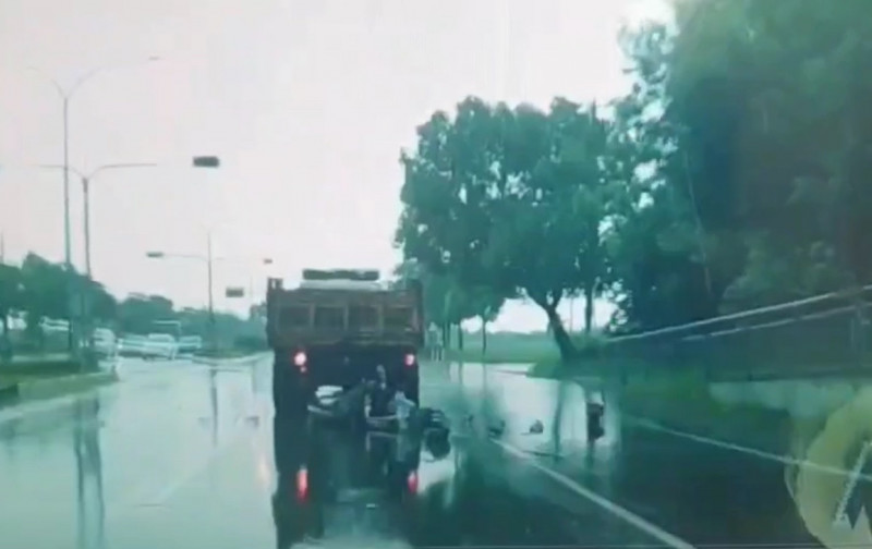 大學生情侶共乘機車追撞等停紅燈的砂石車，後方車輛行車紀錄器拍到機車倒地。（記者楊金城翻攝）