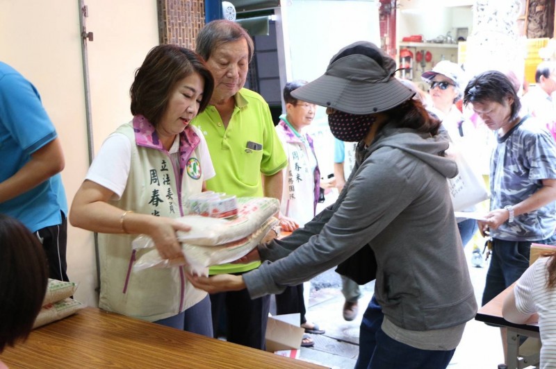 屏東都城隍廟發放白米和紅包給低收入戶，立委周春米帶領服務處的工作伙伴協助廟方發放愛心。（周春米服務處提供）