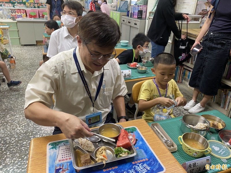 高雄市教育局長謝文斌（左）與呂姓男童同桌吃飯。（記者黃旭磊攝）