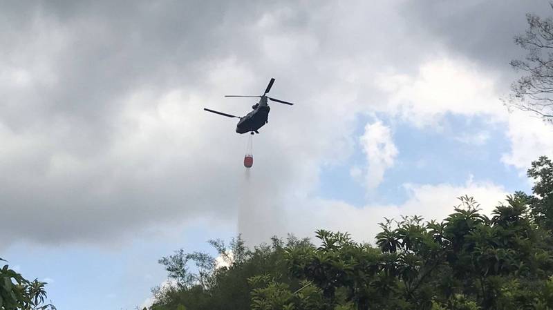 高雄市美濃地區今年清明節前後發生多起火燒山，一度動用直升機載運水袋灑水滅火，警方調閱監視器畫面，查獲傅姓男子天真以為可以領補助而縱火，橋頭地檢署依森林法將他起訴。（陸軍航特部提供）