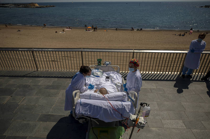西班牙巴塞隆納海邊的德爾馬醫院施行「人道」加護病房計畫，讓武漢肺炎患者可以到海灘享受10分鐘空氣與陽光。（美聯社）
