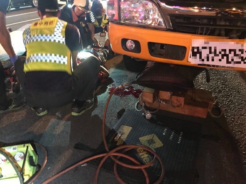 消防人員先放置輪擋固定車輛，使用氣動頂舉袋及木頭墊塊撐高車體，迅速協助洪男脫困。（記者何宗翰翻攝）