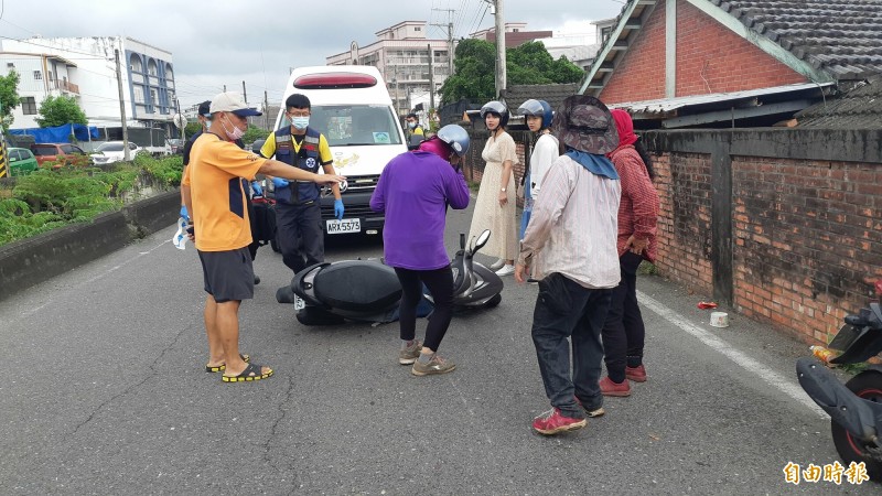 台東市綏遠路下午發生車禍，現場有路過的美眉（戴安全帽著洋裝者）協助處理，留下美麗身影。挨撞老婦（紫衣者）還能站立，向救護人員說明傷勢狀況。（記者黃明堂攝）