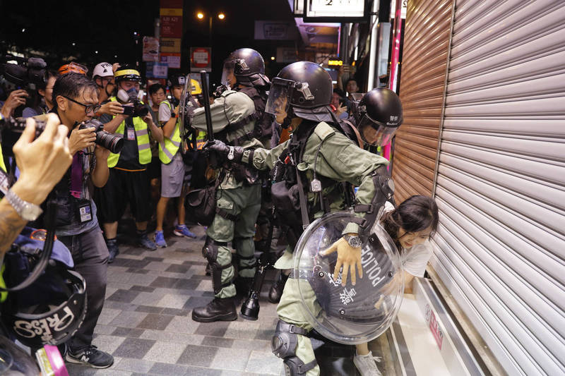 港警去年8月在反送中集會上，拘捕一名手無寸鐵的少女。（美聯社）