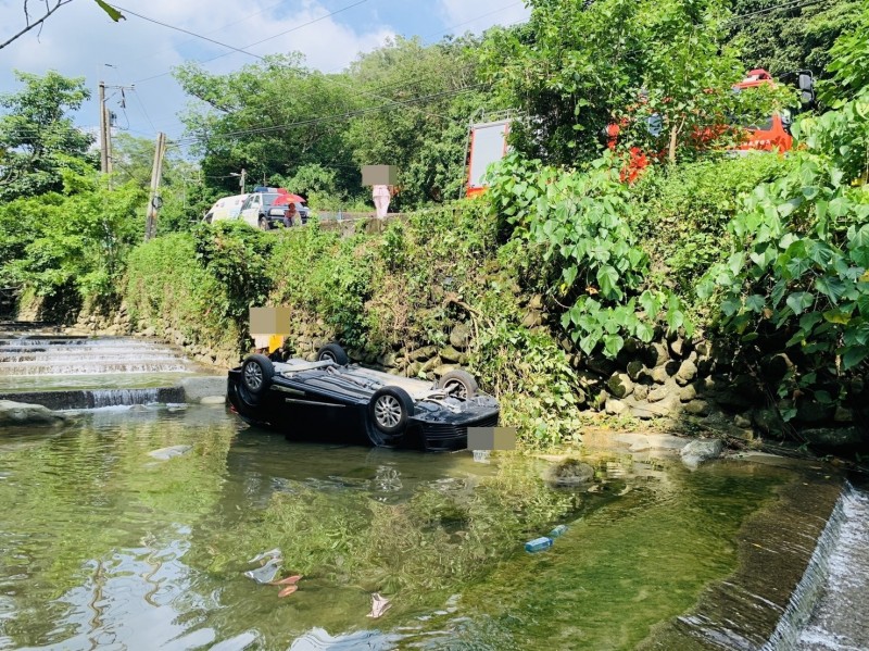 黑色小客車4輪朝天翻落高雄美濃的水底溪。（記者許麗娟翻攝）