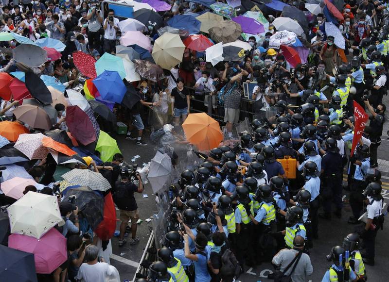 六年前的雨傘運動被喻為香港民主運動的開端。對此，羅冠聰表示，六年前的一戰，是他無休止旅程的起點，也是香港人奔向自由的重要一章，而「運動的成功與失敗，在於結果，也在於啟發了多少誓不休戰的覺醒青年。」圖為香港2014年9月28日，數萬名市民上街示威，並撐起雨傘抵擋港警的胡椒噴霧攻勢。（路透）