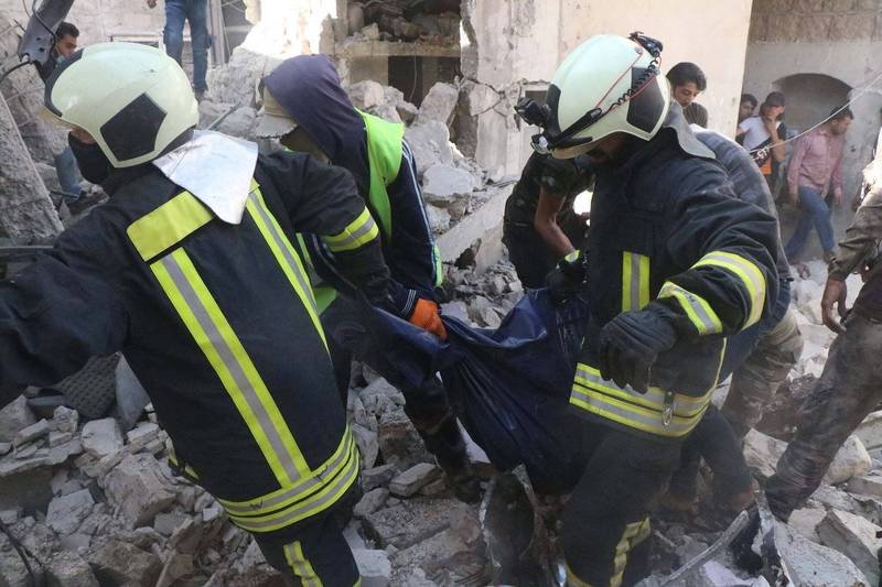 敘利亞西北部城鎮巴布6日發生卡車炸彈爆炸案，確認至少有11人喪生、數十人受傷，圖為敘利亞白頭盔組織將死者扛出。（美聯社）