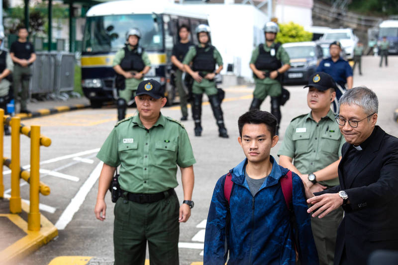 香港人陳同佳（前排中）前年在我國殺害港籍女友案，在港出獄一年都未前來台自首，他今日不直接連絡特設窗口，另委託我國律師向檢警單位接洽；對此，中國北京市政協委員、牧師管浩鳴（前排右）指稱，因為陳同佳國語欠佳需要口譯。（彭博資料照）