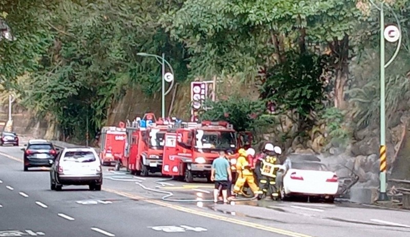 南投縣警方及消防人員協助交管及灌救自小客車起火情形。（南投縣警察局集集分局提供）