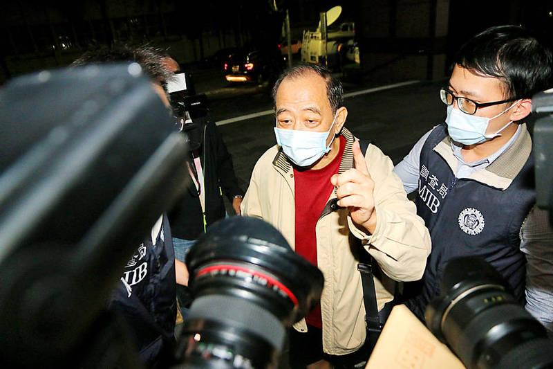 Former Military Intelligence Bureau colonel Chang Chao-jan talks to reporters yesterday while being escorted by a Ministry of Justice Investigation Bureau officer at the Taipei District Prosecutors’ Office.
Photo: CNA Former Military Intelligence Bureau colonel Chang Chao-jan talks to reporters yesterday while being escorted by a Ministry of Justice Investigation Bureau officer at the Taipei District Prosecutors’ Office.
Photo: CNA