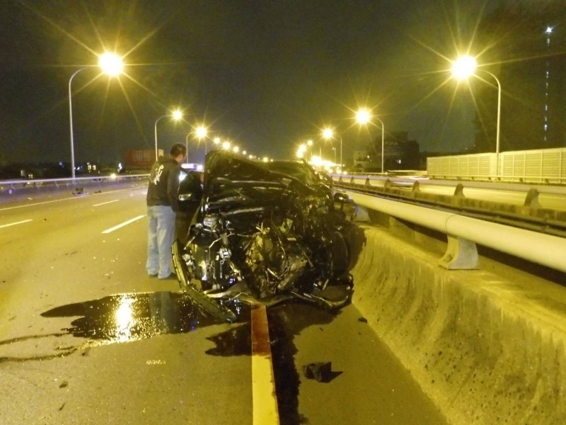 賓士車車頭撞爛，拖吊業者（圖左）看得有點傻眼。（記者張瑞楨翻攝）