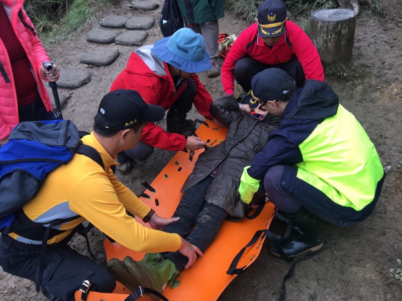 消防員協助將受傷的74歲阿嬤搬運下山。（記者林敬倫翻攝）