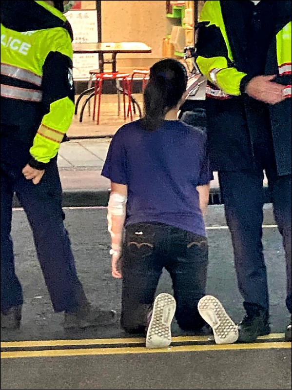 新北市楊女遭滷味攤老闆解雇，長跪路口央求，林口警分局員警到場防護，避免她遭車撞。（記者吳仁捷翻攝）