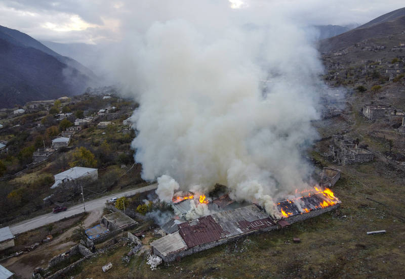 當地居民無奈親手點火燒毀家園，濃煙充滿了整個山谷。（美聯社）