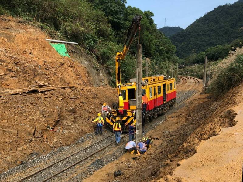 台鐵瑞芳猴硐段坍塌，為了力拚完成明天東正線單線雙向通車，台鐵人員今天清運土方告一段落後，趕緊架設電力桿。（圖為台鐵提供）