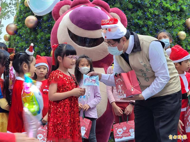 台南購物節「藝童過YA誕-慢慢來市集?，台南市長黃偉哲（右）與小朋友交換禮物。（記者劉婉君攝）