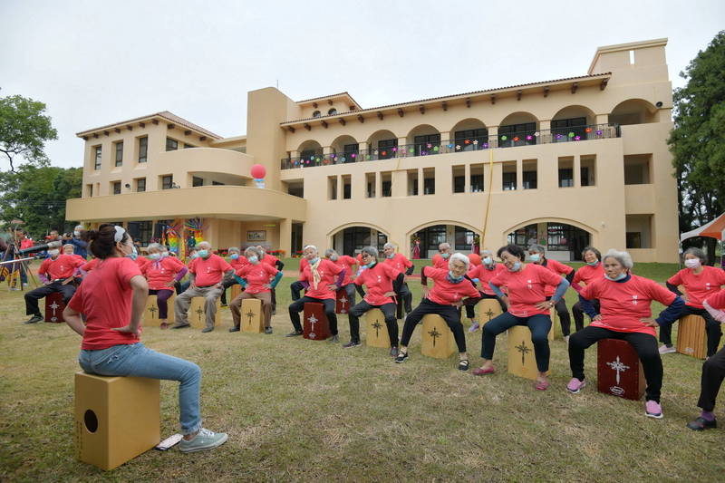 南投縣田豐國小新建校舍落成，社區阿公阿嬤們在宛如西班牙莊園的校舍前表演。（南投縣政府提供）