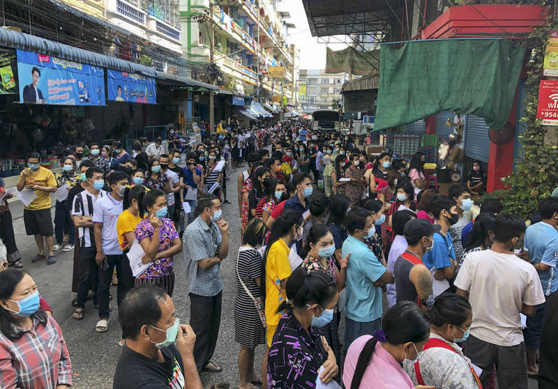 曼谷市府日前宣布新的防疫禁令，關閉俱樂部、按摩店及賭博場所。圖為泰國民眾在篩檢站外大排長龍。（美聯社）