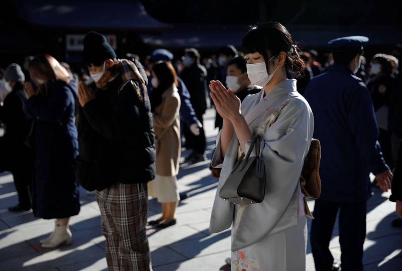 圖為日本民眾1月1日戴上口罩到明治神宮參拜祈福。（路透）