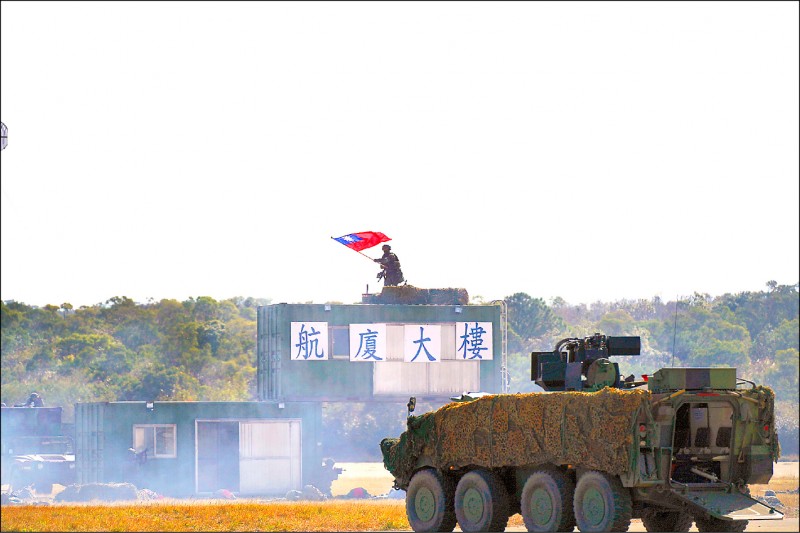 陸軍584旅聯兵1營進行機場攻防演練，官兵殲滅敵軍後，在航廈佈景上揮舞國旗。（記者涂鉅旻攝）