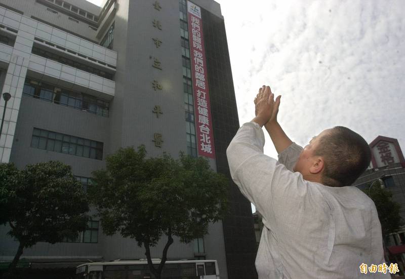 圖為2003年4月和平醫院爆發疫情封院後，一名路人跪在醫院前路邊雙手合十向上天禱告。（資料照）
