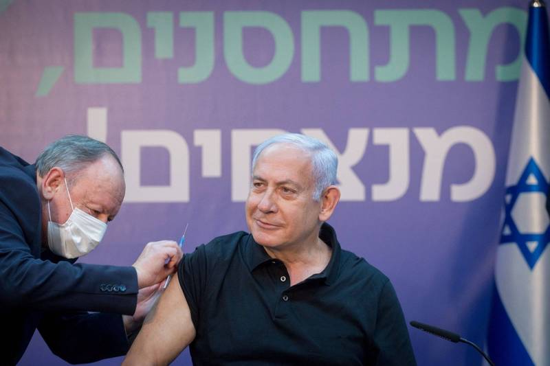 以色列總理納坦雅胡鼓勵老年人踴躍接種武漢肺炎疫苗，強調若有人害怕可以提供電話號碼，孰料卻因疑似侵犯隱私而被臉書刪除文章。納坦雅胡施打疫苗示意圖。（路透）
