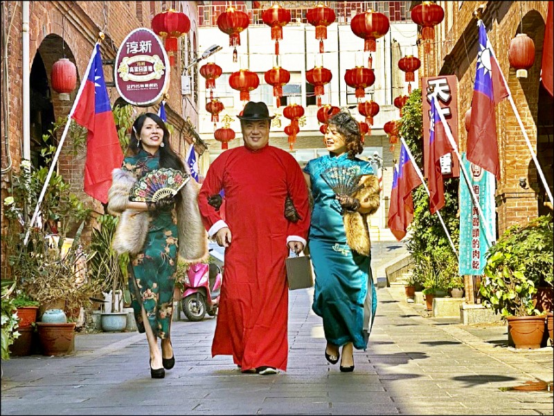 金門縣金城鎮即日起在「模範街」掛起喜氣洋洋的大紅燈籠，將農曆春節的氣氛聚焦在這座1924年由金門縣商會集資興建的老街上，鎮長李誠智（中）昨身穿大紅長袍，在兩名仕女的陪同下模擬「民國初年風」，向遊客、鄉親提前賀年。

 李誠智說，「模範街」是根據南洋引進的「五腳基」形式建築，街道兩旁都是二進店屋，第一進為洋樓、第二進為閩式建築，外觀整齊、古典雅致，兼具民國初年的建築風格及洋樓的美感，是觀光客拍照打卡首選，還可順遊國定古蹟邱良功母節孝坊及靈濟古寺、後浦藝文特區等景點。

（圖文：記者吳正庭）