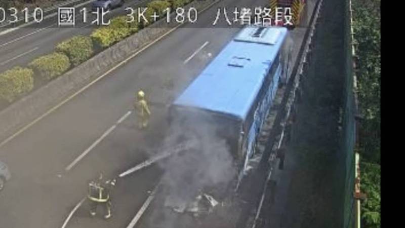 基隆客運一輛開往基隆的客運今天上午11時許行經國道一號北上八堵路段，車尾突然竄出黑色濃煙。基隆市消防局緊急出動8車18名消防員馳援，迅速控制火勢。（記者林嘉東翻攝）