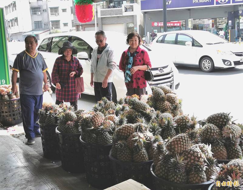 買鳳梨、吃鳳梨已成為全民運動，關廟農民張德男的批發、零售站，買氣熱絡。（記者吳俊鋒攝）