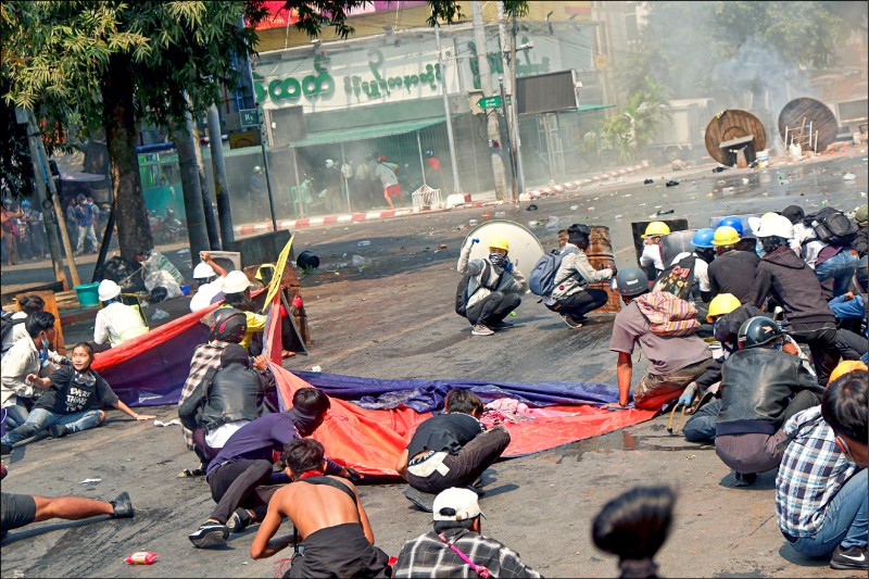 緬甸警方3日開火驅散曼德勒街頭抗議群眾，華裔女大生鄧加希（圖左下）當場頭部中槍身亡。（路透）