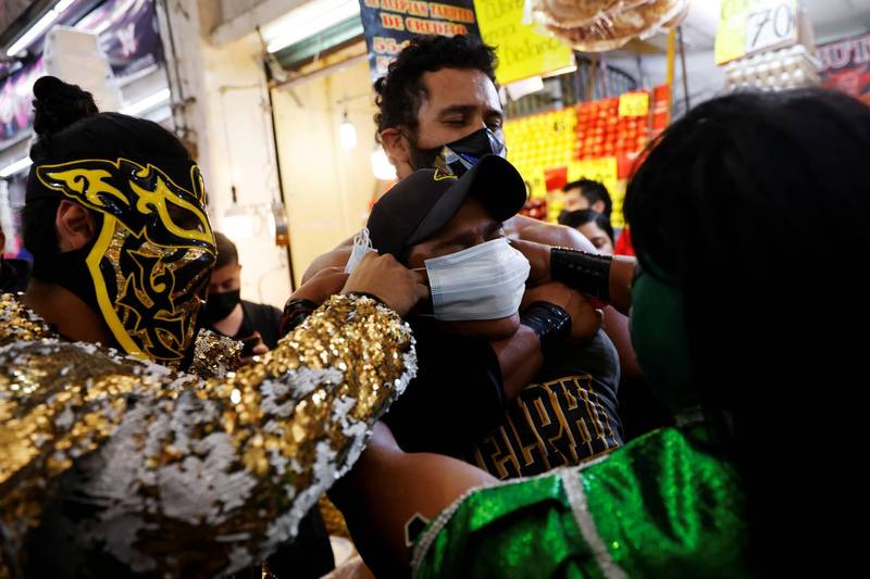 墨西哥当地市场出现了一群墨西哥摔角选手，他们只要看到没戴口罩的民众，就会帮他们戴上口罩，并且为他们提供酒精。（路透）(photo:LTN)