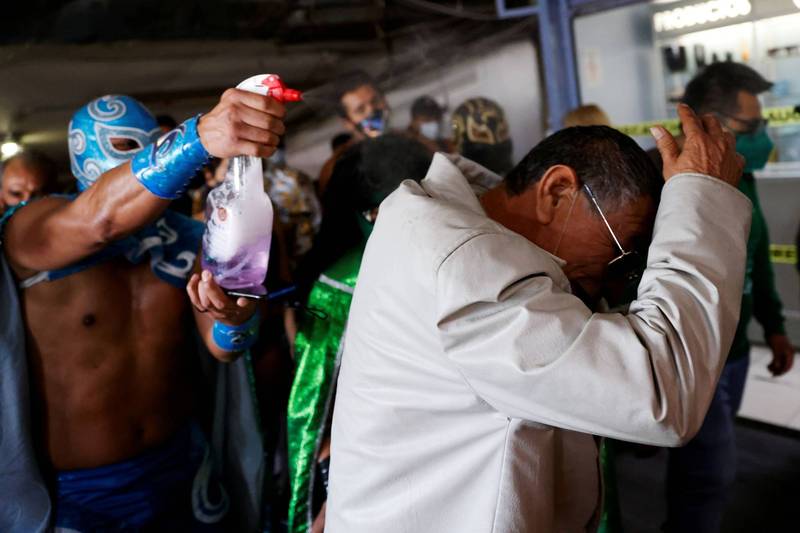 墨西哥摔角选手，还会帮民众喷上防疫用的喷液。（路透）(photo:LTN)
