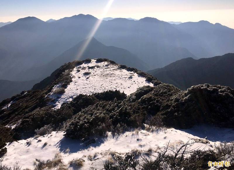 玉山「3月雪」在陽光照耀下，呈現出殘雪點綴山頭的美感。（謝姓山友提供）