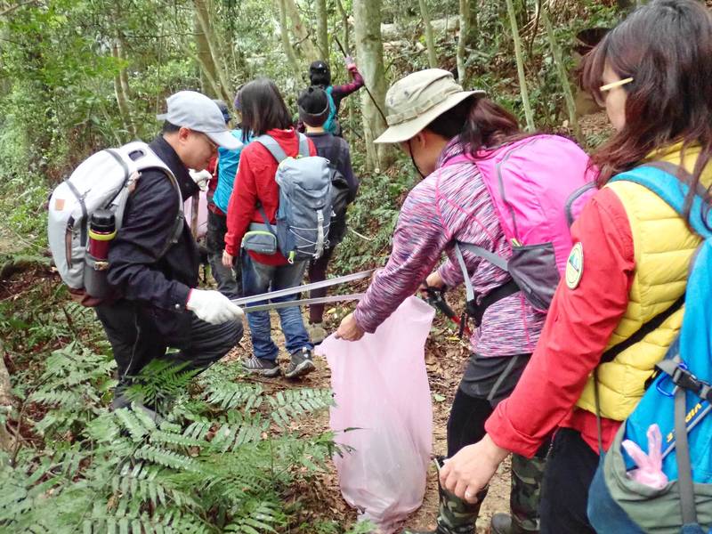 苗栗社大學員走古道兼淨山，撿拾沿途的垃圾。（記者張勳騰翻攝）