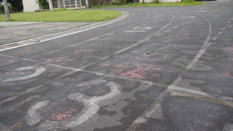 基隆多雨加上操場跑道年久老舊，隨處可見裂縫、凹陷。（立委蔡適應服務處提供）