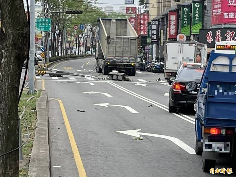 大貨車行經烏日區中山路時，疑似卸完貨忘記將車斗降下，扯斷路上紅綠燈。（記者何宗翰攝）