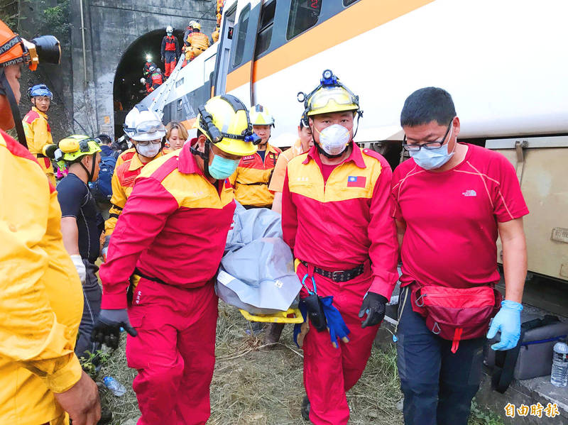 Keelung Fire Department firefighters remove a body from one of the cars after yesterday’s train crash in Hualien.
Photo copied by Lin Chia-tung, Taipei Times Keelung Fire Department firefighters remove a body from one of the cars after yesterday’s train crash in Hualien.
Photo copied by Lin Chia-tung, Taipei Times