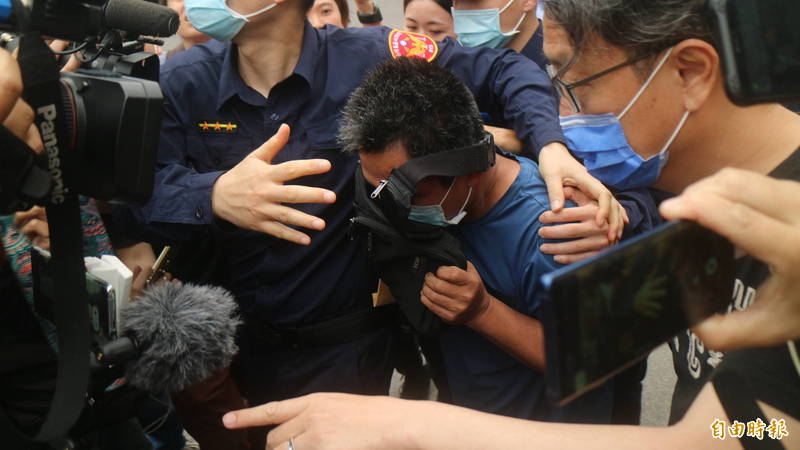 李義祥交保後拿黑色小包包遮臉離開法院。（記者王錦義攝）