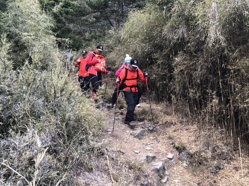 消防人員將受傷李女背負下山。（記者歐素美翻攝）