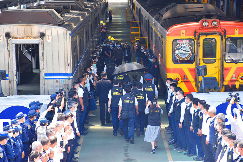 People bid farewell to train driver Yuan Chun-hsiu, who was killed in a train crash on Friday last week, as railway police escort his ashes and family members to a train departing from Hualien County for his hometown of Taichung yesterday.
Photo: CNA