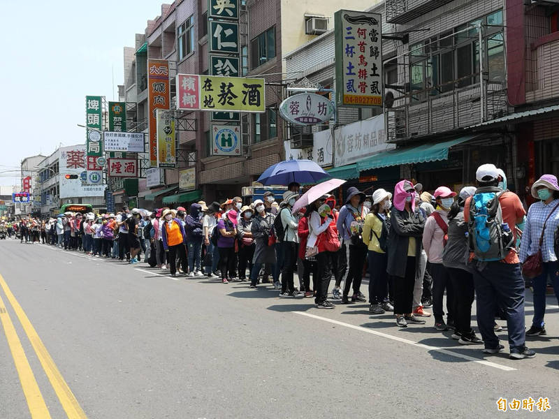 想鑽轎腳的民眾大排長龍，大家都乖乖地戴上口罩。（記者顏宏駿攝）